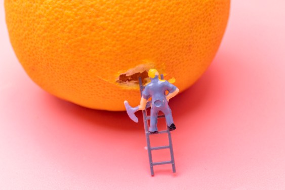 Close-Up Of Figurines working on the Orange Over pink Background
