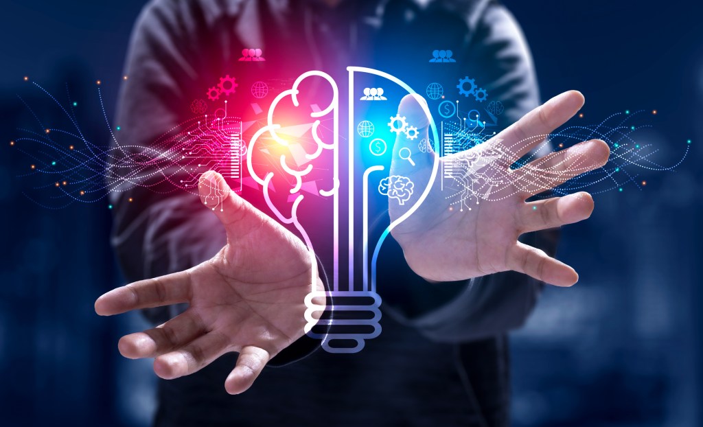 Man's hands around a light bulb split in two. One side represents AI as a platform, the other as a product.