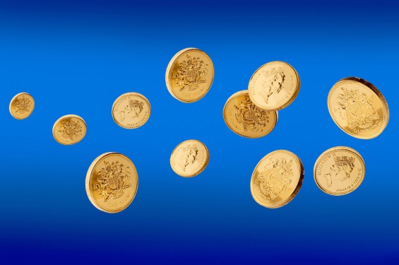 Pound coins in mid air against a blue background