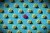 a photo of a pattern of yellow ducks on a blue vignetted background, with a single red duck in the middle