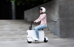 Woman riding the new Honda Motocompacto e-scooter in a city
