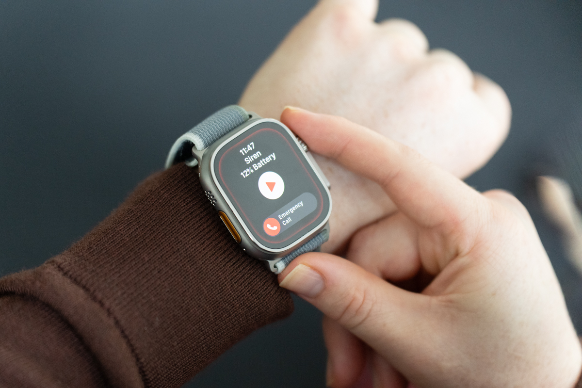 Apple Watch Ultra 2 on a wrist, with the Siren app open and the wearer's finger on the Digital Crown