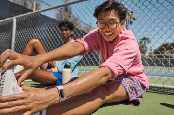 man stretching, wearing Fitbit