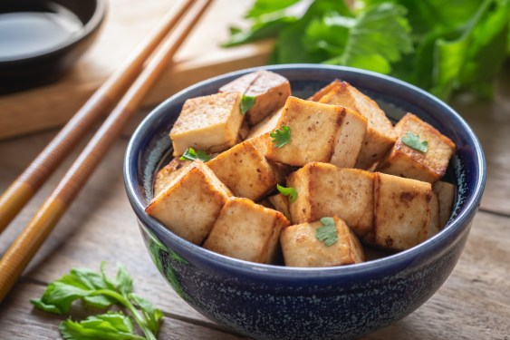Fried Tofu in a bowl with chopped sticks.