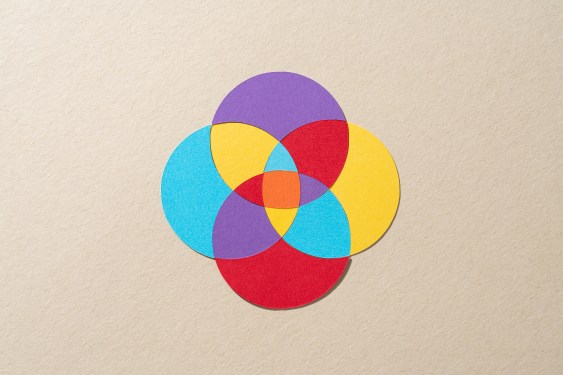 Paper Craft Multi Layered Colorful Venn Diagram Composed of Four Crossing Circles on Beige Background Directly Above View.