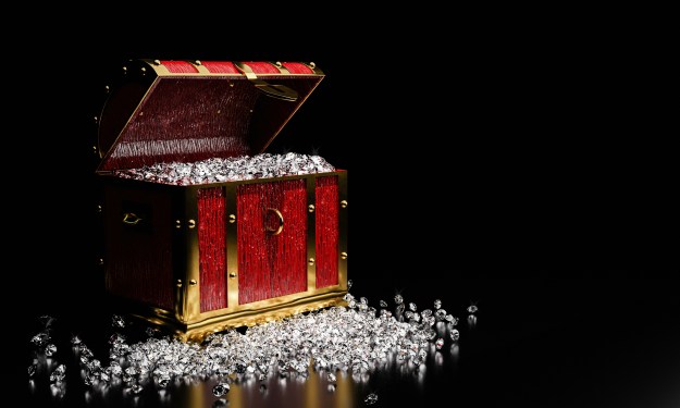 Diamonds in a vintage treasure chest, spilling onto the ground