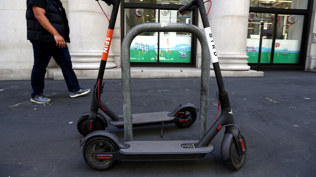Spin and Bird scooters on a sidewalk