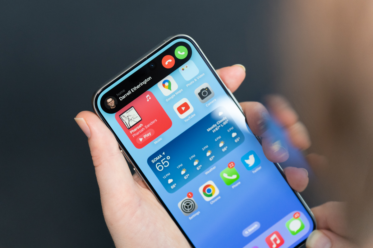 iPhone 15 Pro Max in natural titanium, being held, showing the display and the Dynamic Island