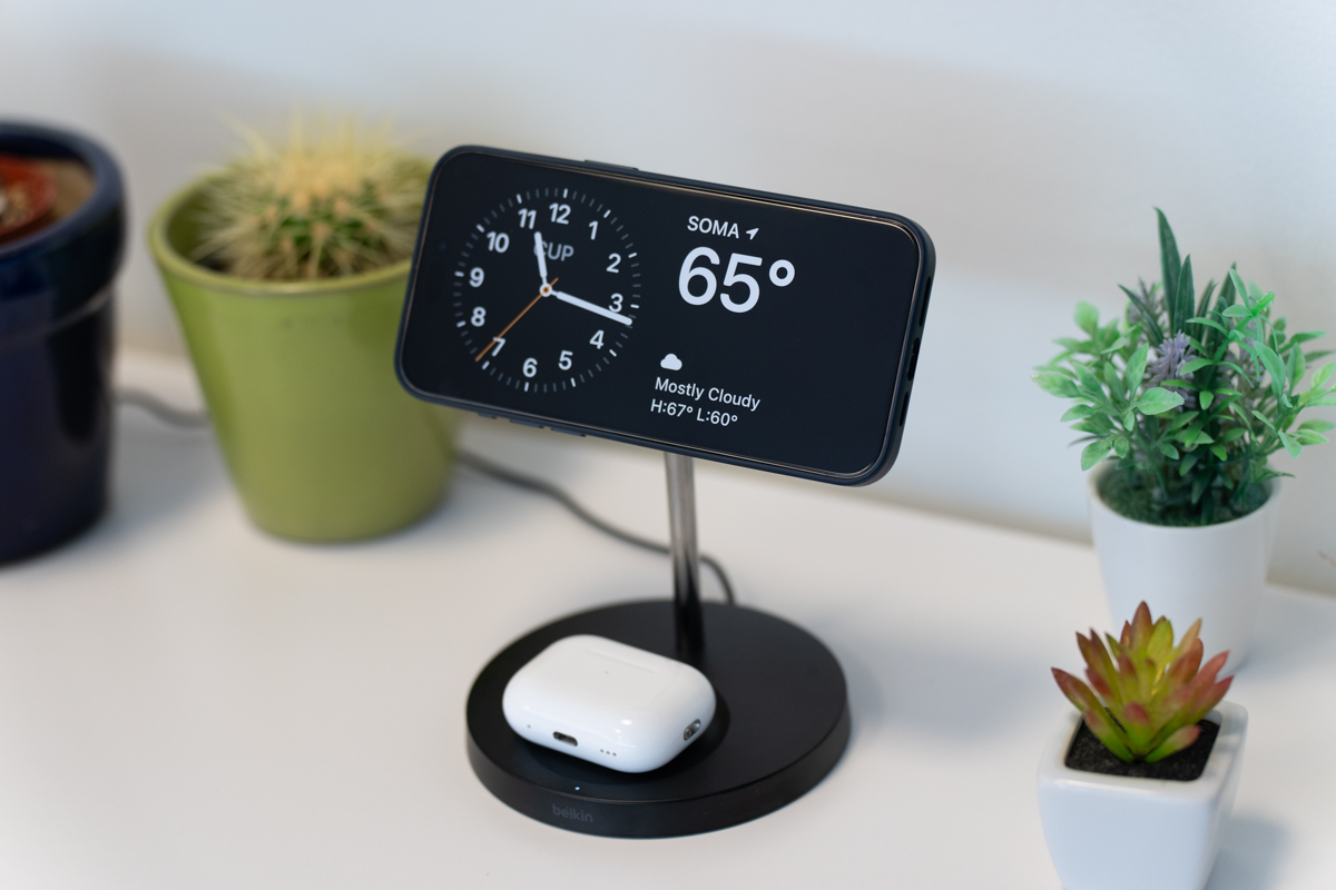 iPhone 15 Pro Max on a charging stand with AirPods Pro 2
