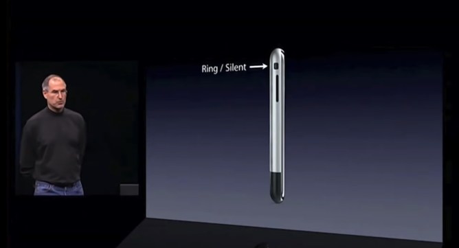 Steve Jobs next to a screen showing the silent switch on an early iPhone