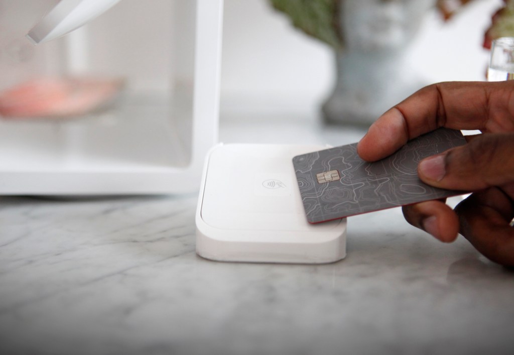 Customer using contactless payment at modern wine bar counter, close-up