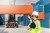 Dock control worker in front of stack of a containers.