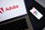 Adobe log on a laptop and Figma logo on a smartphone.