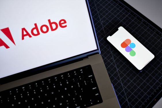 Adobe log on a laptop and Figma logo on a smartphone.