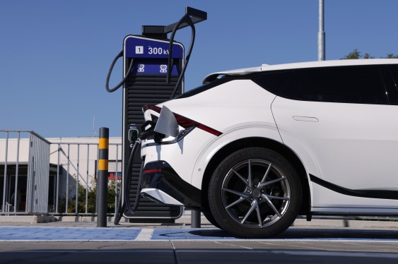 A white electric car charges at a public charging station in Germany