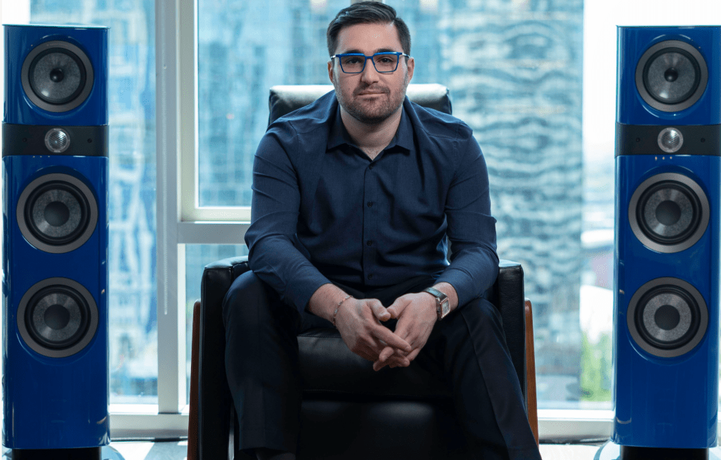 KIT Plugins founder Matt Kleinman sitting between two tower speakers