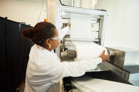 Woman working on membrane filter production line.