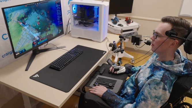Ben plays a real-time strategy game at a PC using a mouse and accessible controllers.