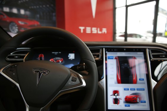 Closeup of a steering wheel showing the Tesla logo