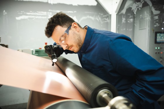 A worker examines copper at a Redwood Materials factory.