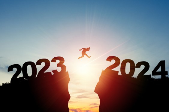 Man leaping over canyon with 2023 on one side and 2024 on the other.