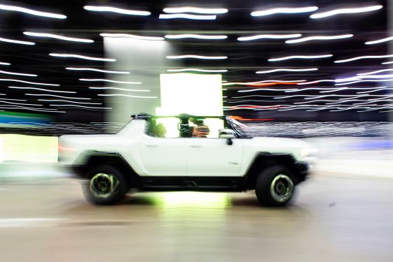 A 2024 Hummer EV SUV carrying attendees rounds a corner of a test track during the North American International Auto Show at the Huntington Place convention center in Detroit, Michigan, on September 14, 2023.