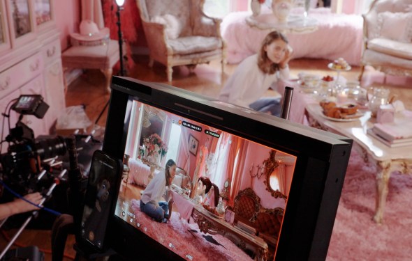 A photo of a camera feed that shows a virtual character interacting with a real person on set.