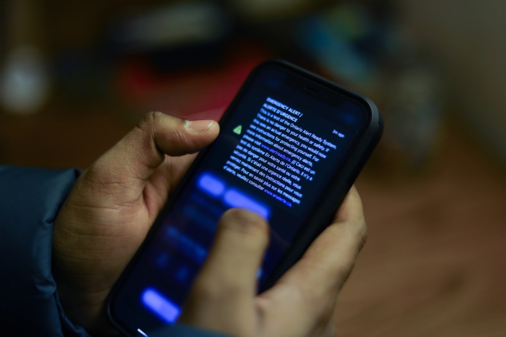 a push notification appearing on an iPhone held in someone's hands on a darkened background
