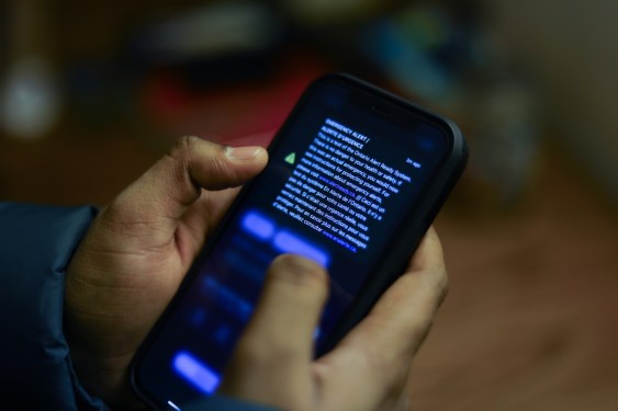 a push notification appearing on an iPhone held in someone's hands on a darkened background