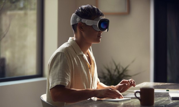 man sitting at desk wearing VR headset