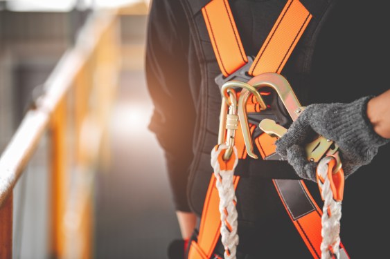 Construction worker wearing safety harness and safety line working high place at industrial.