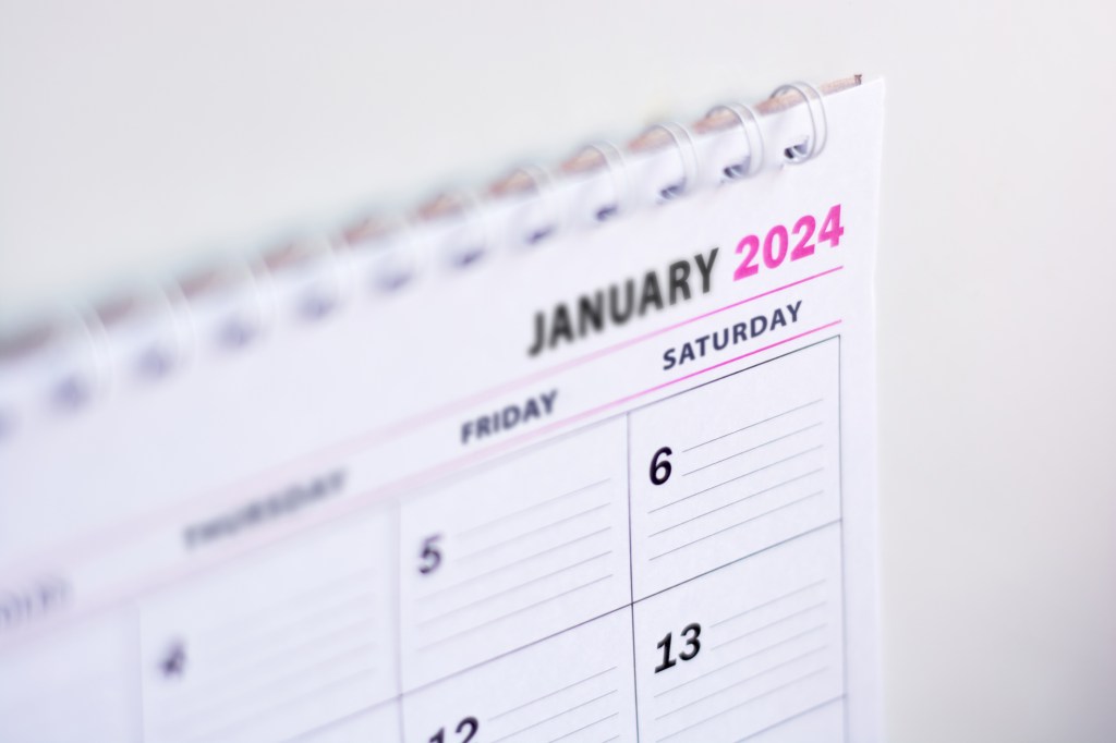 Close up of blank 2024 calendar hanging on fridge with the words January 2024.