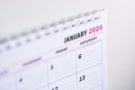 Close up of blank 2024 calendar hanging on fridge with the words January 2024.