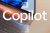 Microsoft Copilot logo with laptop as backdrop