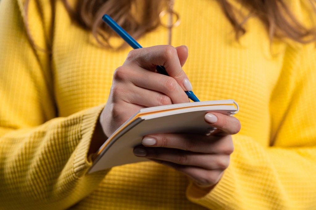Young woman thinking about future plans and to-do list in notebook for week, month, year.