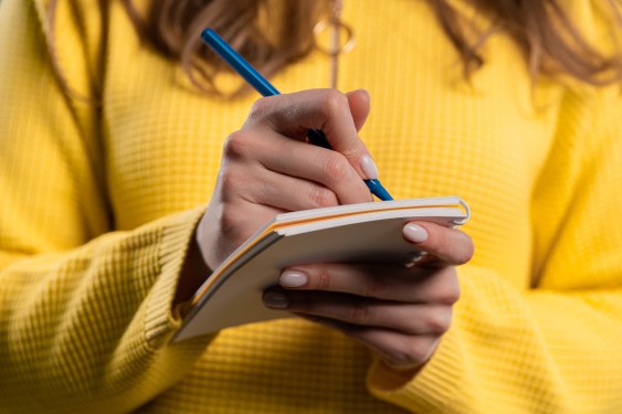 Young woman thinking about future plans and to-do list in notebook for week, month, year.