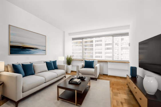 An image of a living room with a sofa, tv, table and pictures frame that were digitally added