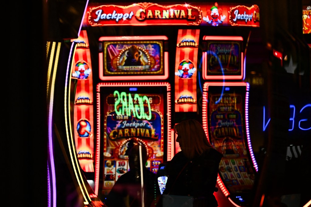 Customers use slot machines inside a casino representing WinStar