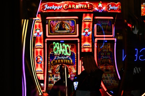 Customers use slot machines inside a casino representing WinStar