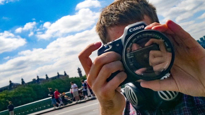 A man takes a photo with a SLR camera