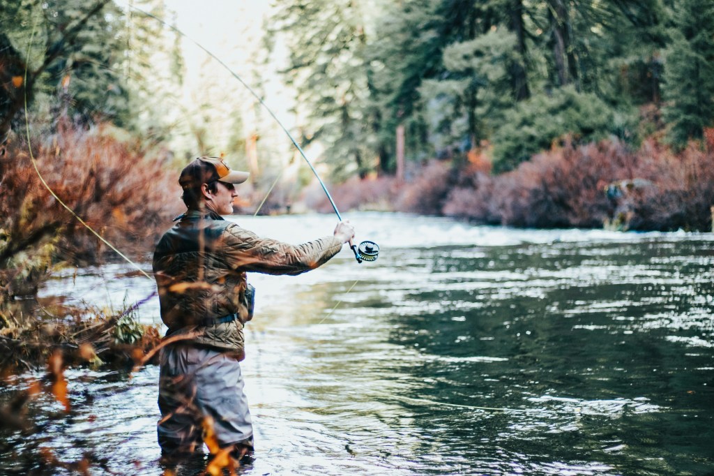 man fly fishing at river's edge