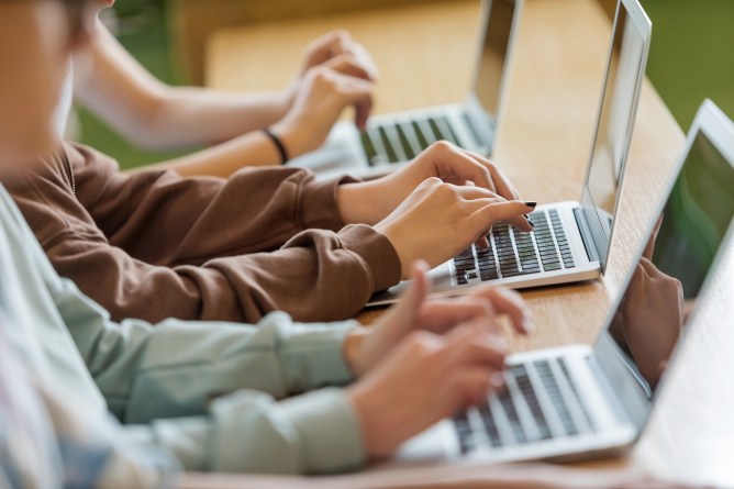students typing on laptops