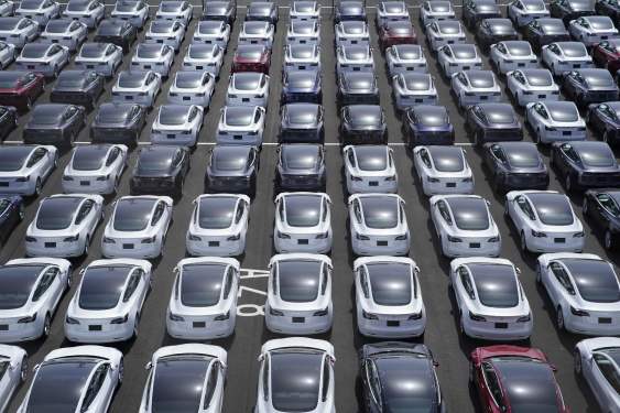 Rows of Tesla vehicles await delivery.