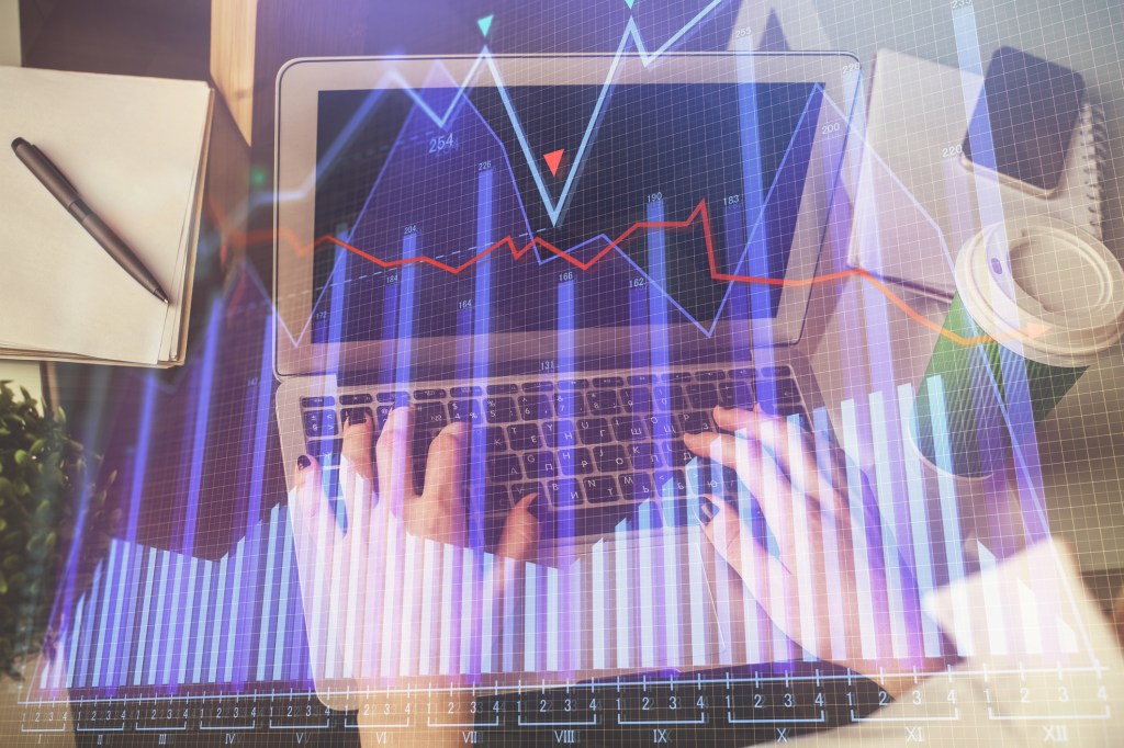 Woman's hands on laptop while data charts and graphs float around her.