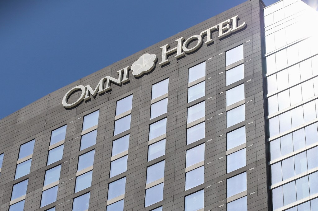 a photo outside of an Omni Hotel looking up at the building facade, with a blue sky