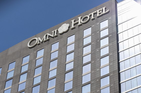 a photo outside of an Omni Hotel looking up at the building facade, with a blue sky