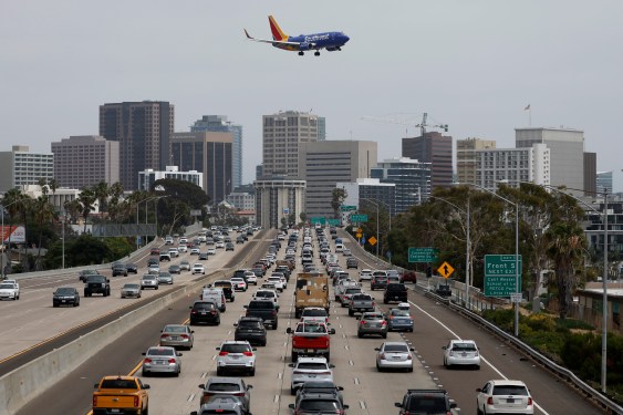 A Southwest Airlines Boeing 737-7H4 approaches San Diego International Airport for a landing from Houston as traffic on southbound Interstate 5 slows during the afternoon commute heading into downtown San Diego