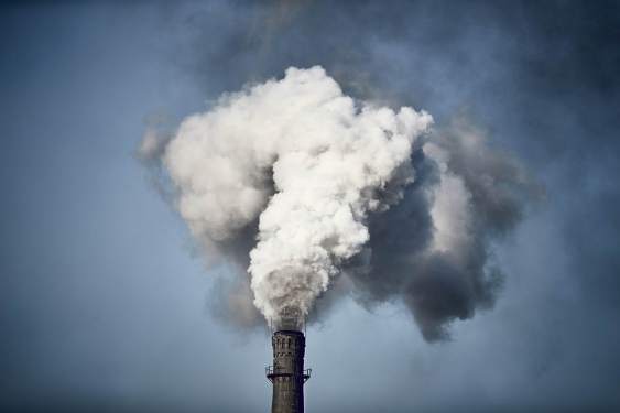 Thick smoke billowing out of the chimney of a Chinese factory.