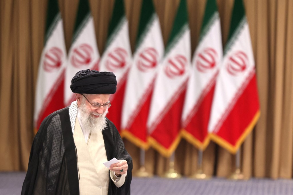 Iran's supreme leader Ayatollah Ali Khamenei prepares to cast his ballot during the runoff of the presidential elections in Tehran on July 5, 2024.