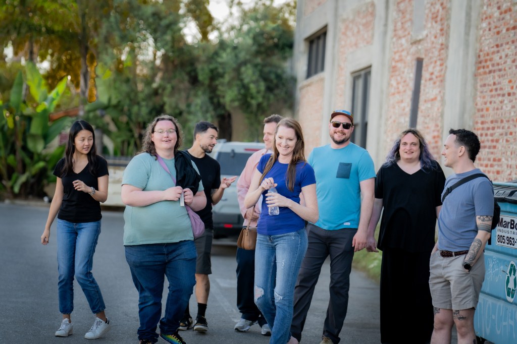 small group of young folks standing in a parking lot